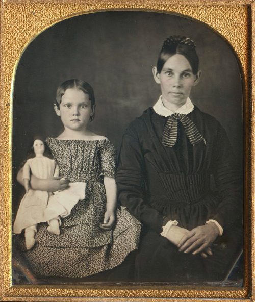 STERN MOTHER, DAUGHTER WITH DOLL.