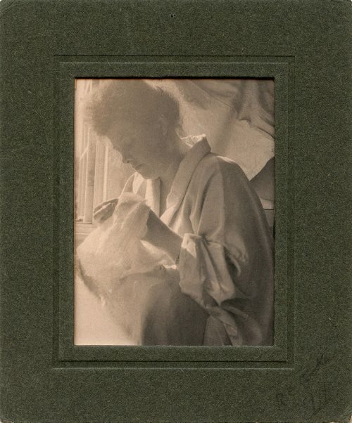 WOMAN SEWING.